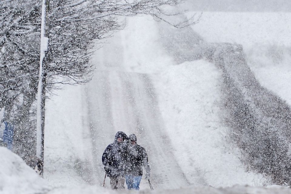 Walkers trudge through the Snow on the Outskirts of Armoy in Northern Ireland. Photo Colm Lenaghan/Pacemaker Press