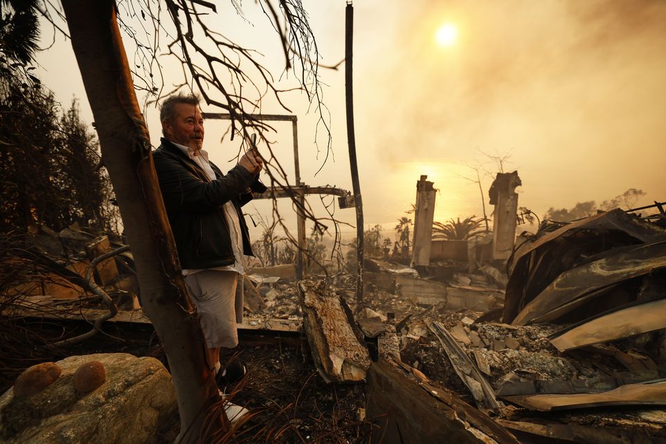 A resident looks at his home damaged by the Palisades fire in Malibu (Etienne Laurent/AP)