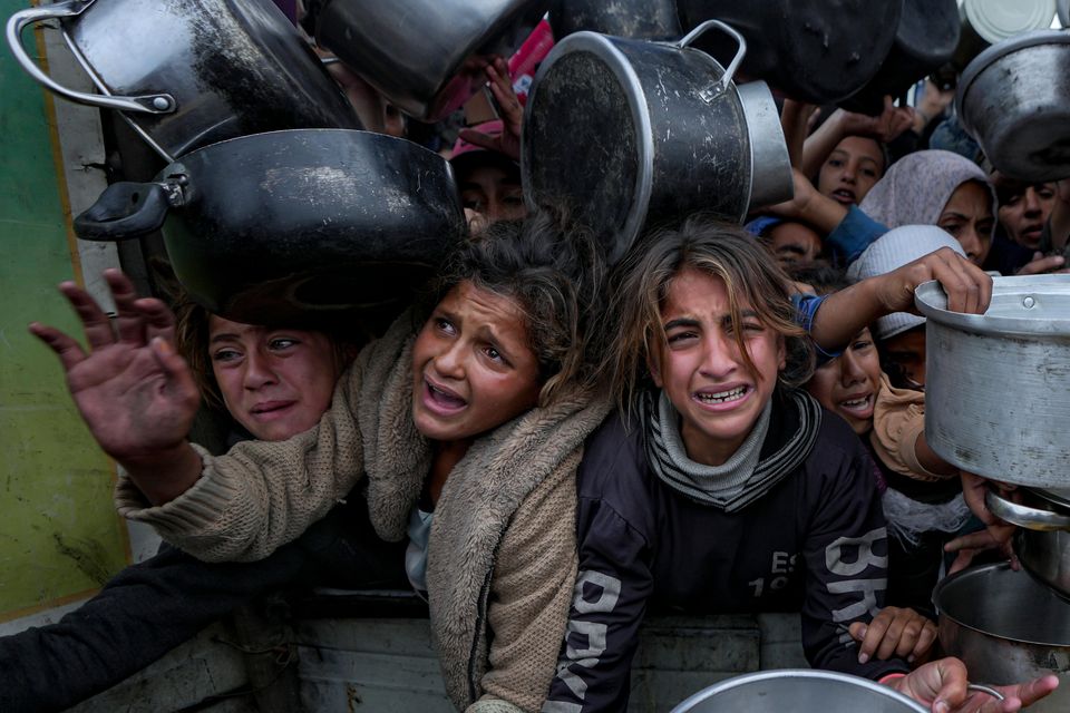 Palestinian women and girls struggle to reach for food in Gaza (Abdel Kareem Hana/AP)