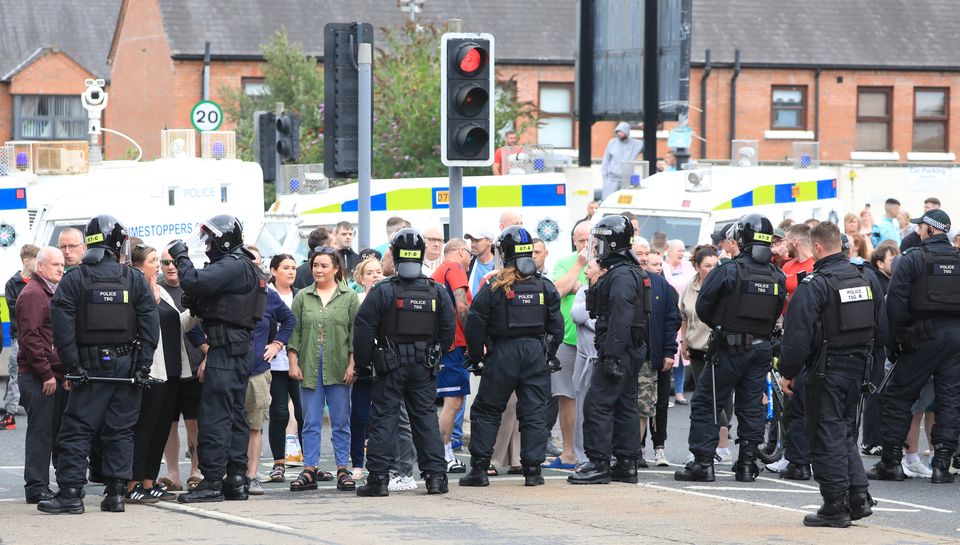 Riot police form a line on the Lower Ormeau Road amid unrest in Belfast (PA)