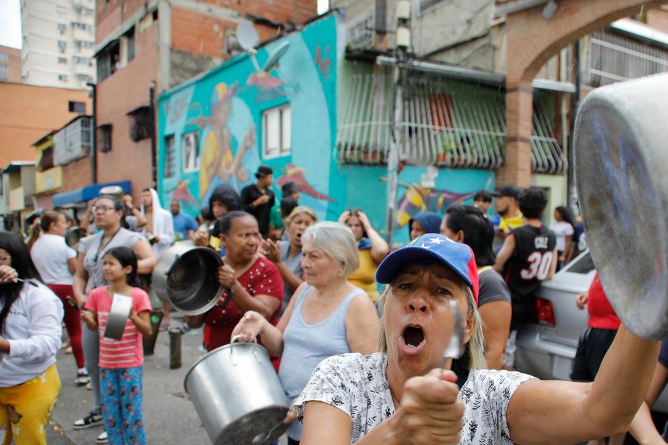 Residents bang pots to protest the day after the presidential election in Caracas (Cristian Hernandez/AP)