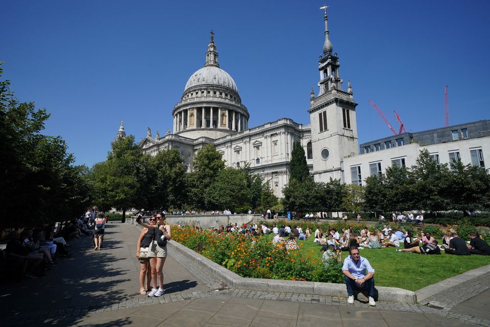 People enjoy the warm weather in Festival Gardens at St Paul’s Cathedral in London (Jonathan Brady/PA)