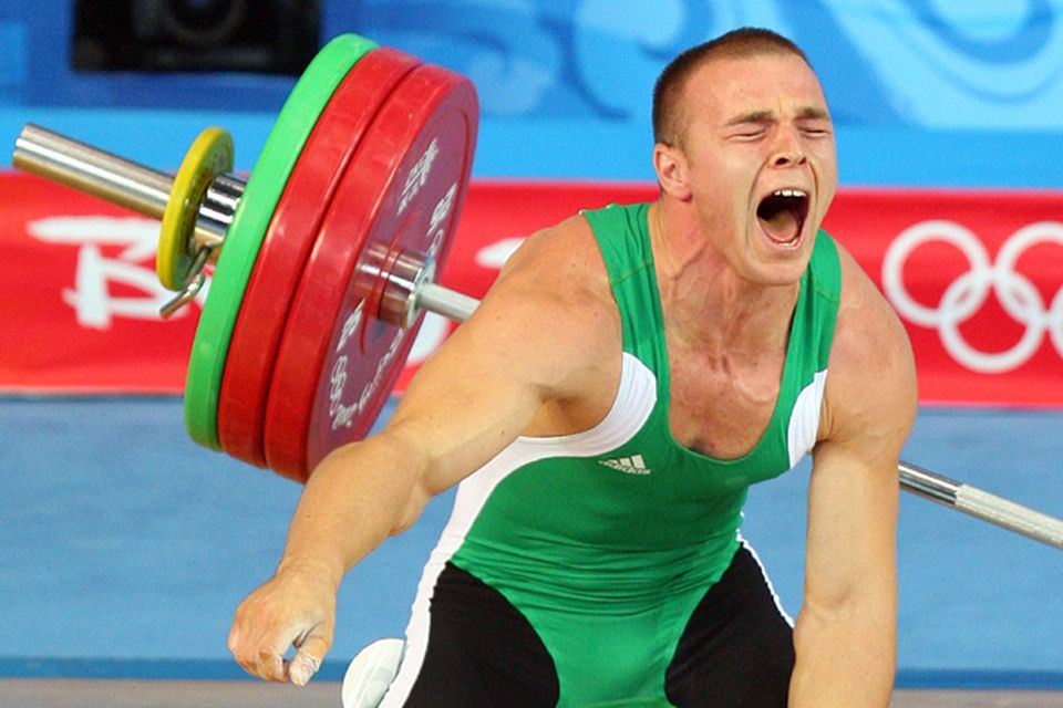 Janos Baranyai of Hungary screams in pain after dropping the weights during the Men's 77kg weightlifting competition event at the University of Aeronautics and Astronautics Gymnasium