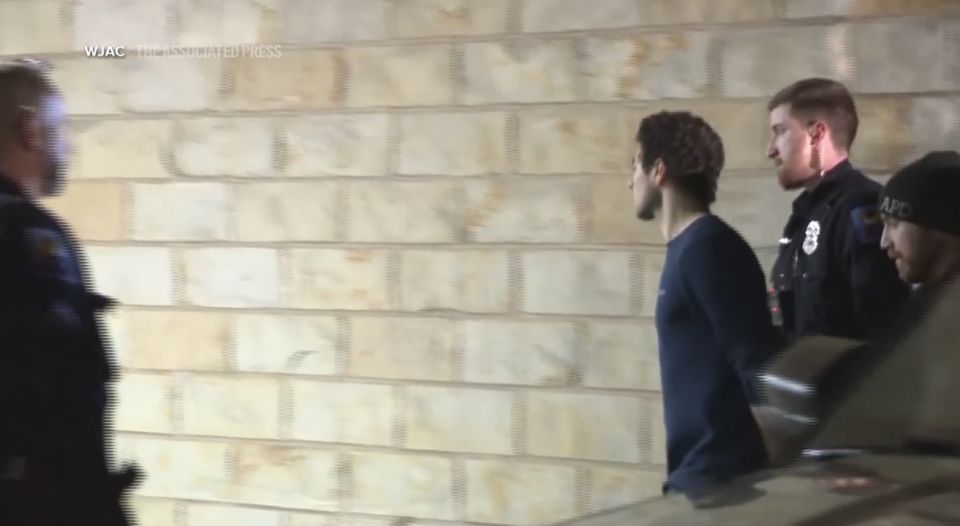 Police officers escorting Luigi Mangione into a court building in Hollidaysburg, Pennsylvania, on Monday (WJAC/Pennsylvania Department of Corrections via AP)