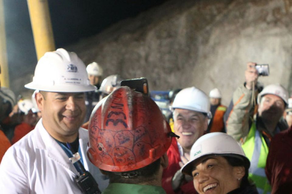 SAN JOSE MINE, CHILE - OCTOBER 12: (NO SALES, NO ARCHIVE) In this handout from the Chilean government, Mario Sepulveda (back to camera), 39, the second miner to exit the rescue capsule, is greeted October 12, 2010 at the San Jose mine near Copiapo, Chile. The rescue operation has begun bringing up the 33 miners, 69 days after the August 5th collapse that trapped them half a mile underground. (Photo by Hugo Infante/Chilean Government via Getty Images)