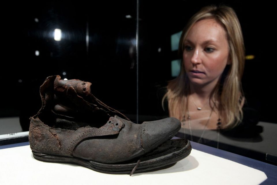 A woman examines a leather boot in an exhibition of artefacts recovered from the wreck of the Titanic on November 3, 2010 in London, England