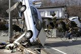 thumbnail: A car leans against a wire from an electric pole in Miyako, northeastern Japan, Saturday, March 12, 2011, one day after an 8.9-magnitude quake and the tsunami it spawned hit the country's northeastern coast