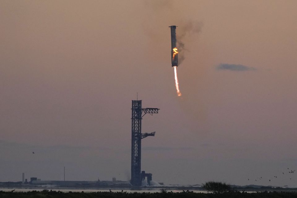 SpaceX’s mega rocket booster returning to the launch pad to be captured during a test flight (Eric Gay/AP)