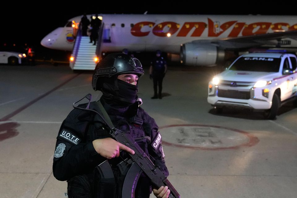 A security force official stands on guard during the arrival of Venezuelan migrants deported from the United States (Ariana Cubillos/AP)