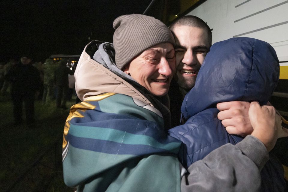 A Ukrainian serviceman hugs his family after returning from captivity during a POWs exchange (Press Service of the President of Ukraine via AP)