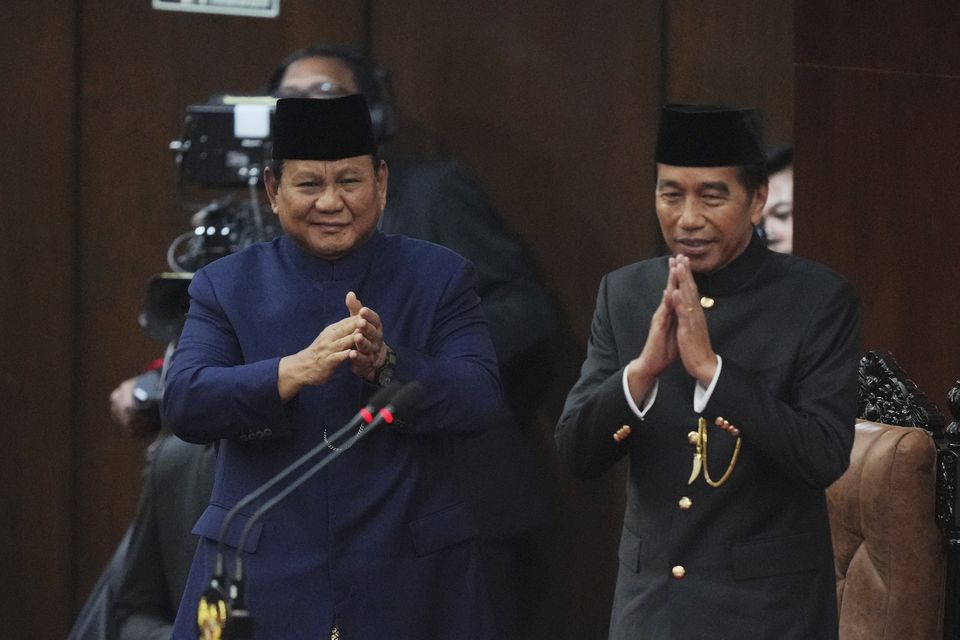 Indonesia’s new president, Prabowo Subianto, left, and former president, Joko Widodo, salute during the inauguration ceremony at the Parliament building in Jakarta (Tatan Syuflana/AP)