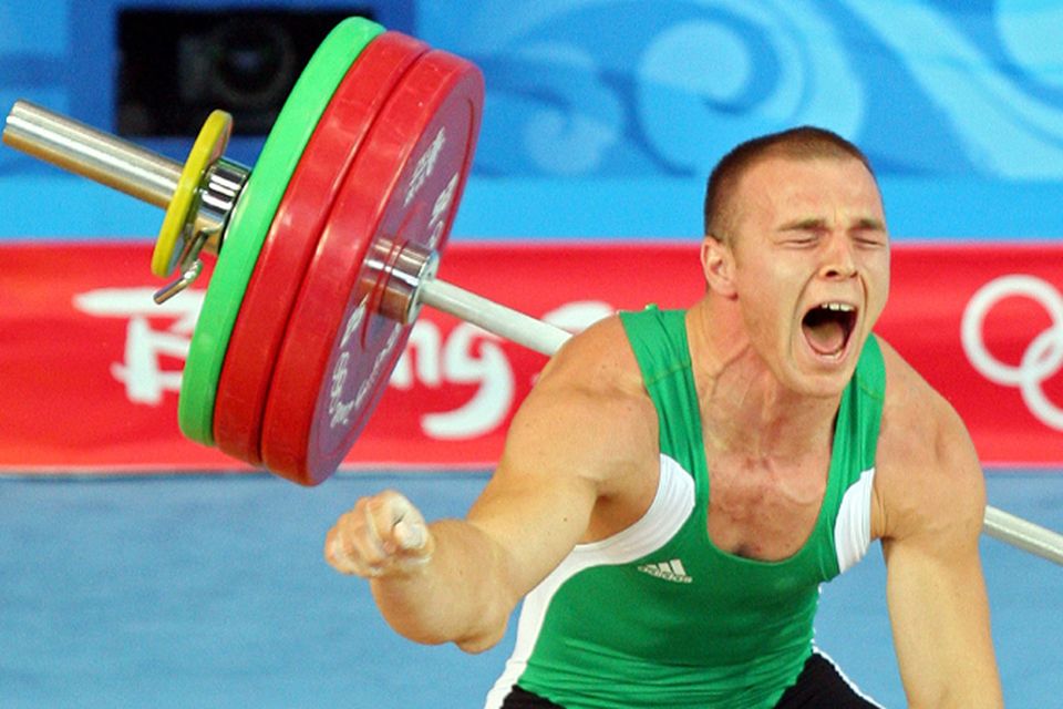 Janos Baranyai of Hungary screams in pain after dropping the weights during the Men's 77kg weightlifting competition event at the University of Aeronautics and Astronautics Gymnasium
