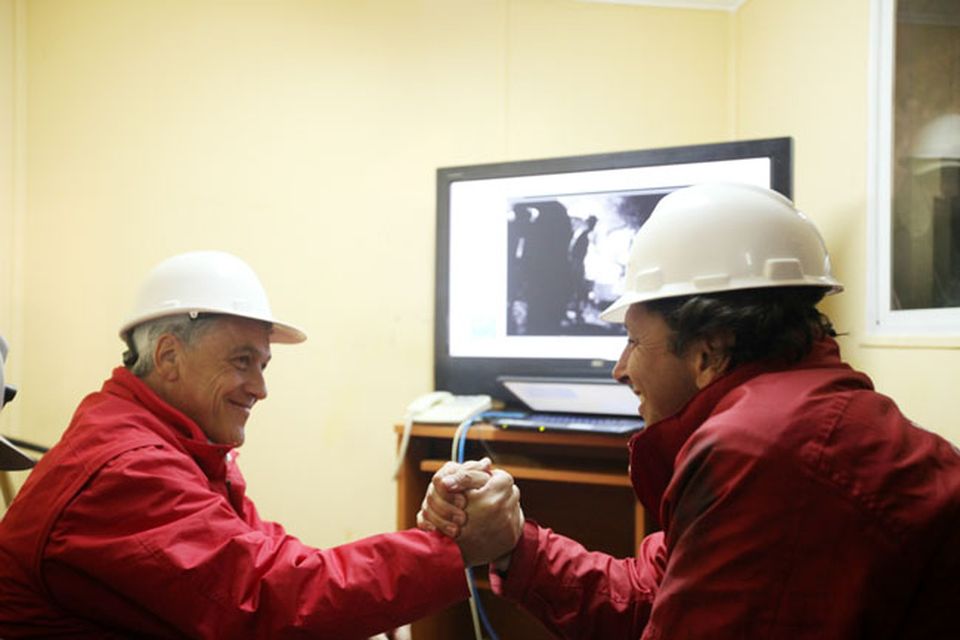 SAN JOSE MINE, CHILE - OCTOBER 12: (NO SALES, NO ARCHIVE) In this handout from the Chilean government, Chilean President Sebastian Pinera (L) and Mining Minister Laurence Golborne shake hands after Roberto Rios, a technical expert arrived at the bottom of the rescue hole October 12, 2010 at the San Jose mine near Copiapo, Chile. The rescue operation has begun bringing up the 33 miners, 69 days after the August 5th collapse that trapped them half a mile underground. (Photo by Hugo Infante/Chilean Government via Getty Images)
