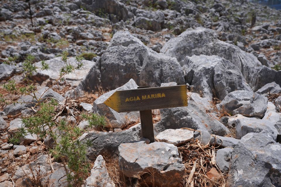 A direction sign on a rocky path in the hills of Pedi, a small fishing village in Symi, Greece, pointing towards Agia Marina, where the body of Michael Mosley was discovered (Yui Mok/PA)