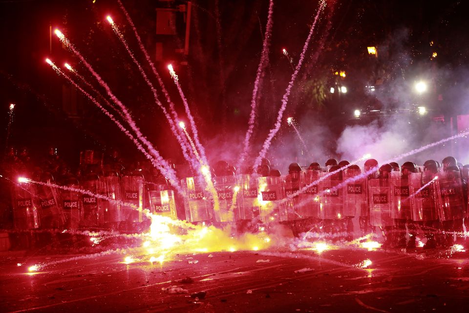 Demonstrators use firecrackers against police during a rally against the Georgian government’s decision to suspend negotiations on joining the EU for four years (Zurab Tsertsvadze/AP)