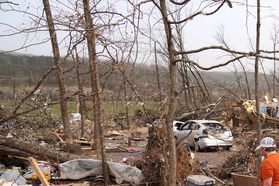 Gina Parish walks through debris left by a severe storm in Wayne County, Missouri (Jeff Roberson/AP)