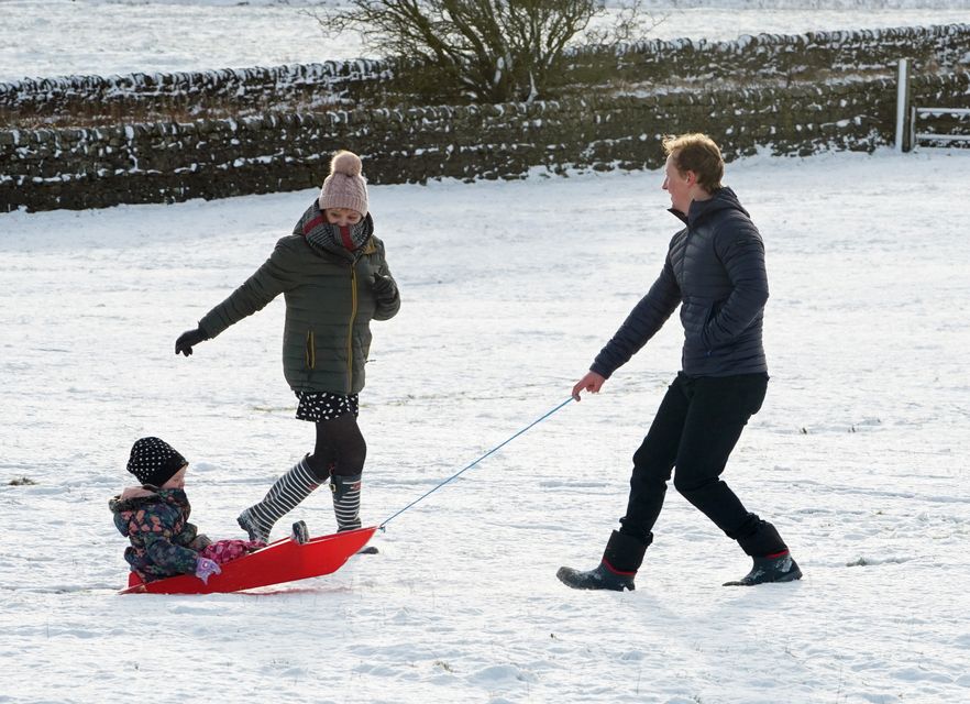 A family take advantage of Christmas Day snow with a trip out sledging on the hills near Hexham, Northumberland (Owen Humphreys/PA)