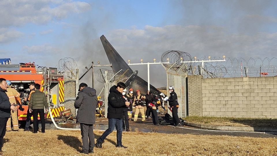 Firefighters and rescue team members work at the Muan International Airport (Maeng Dae-hwan/Newsis/AP)