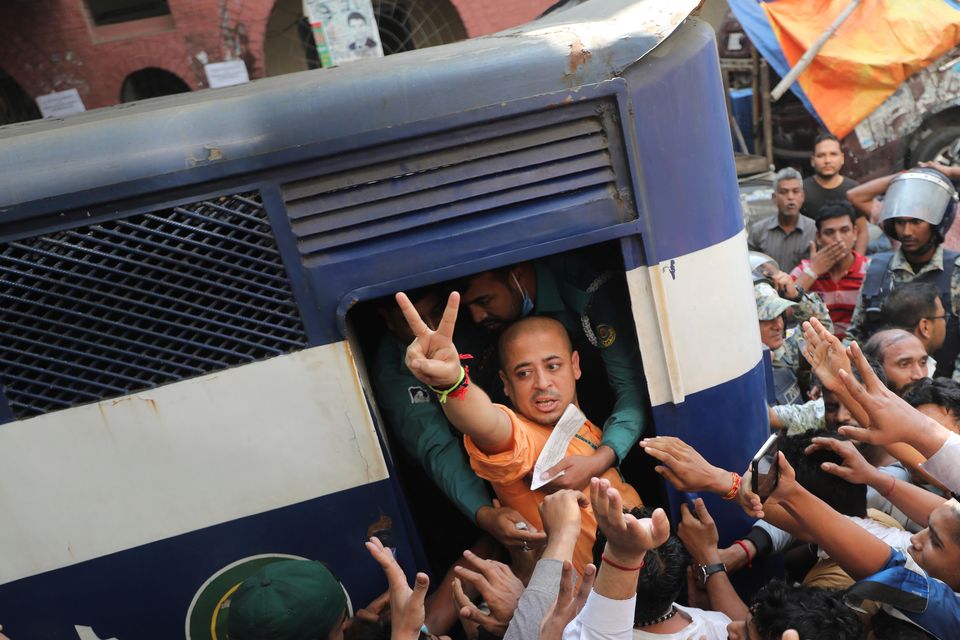 Bangladeshi Hindu leader Krishna Das Prabhu makes a victory sign as he is taken in a police van after a court in Chattogram ordered him to be detained pending further proceedings (AP)