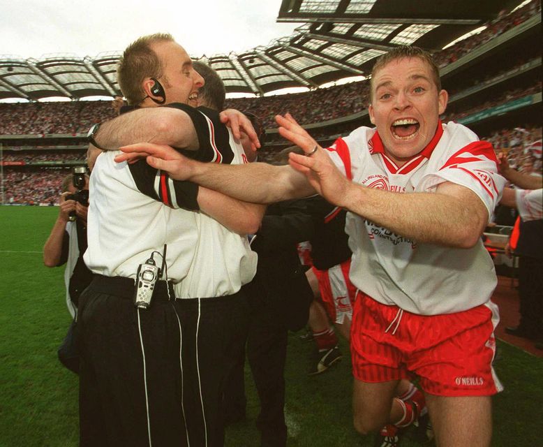 Tyrone manager Mickey Harte and Paddy Tally hug after the 2003 All-Ireland SFC win as Tyrone's Peter Loughran (right) celebrates.