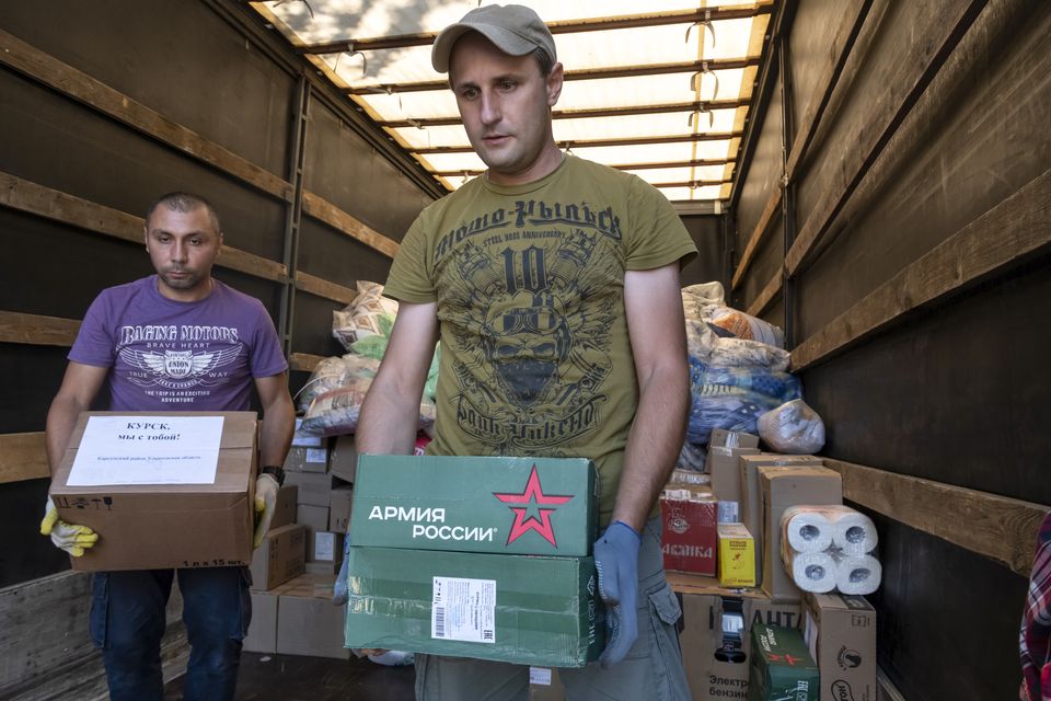 Volunteers at a temporary residence centre in Kursk, Russia, unload humanitarian aid for people evacuated from fighting between Russian and Ukrainian forces in the Kursk region (AP)