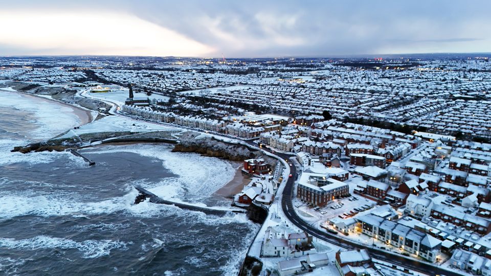 Houses, cars and roads were covered with snow this morning in Cullercoats Bay in North Tyneside (Owen Humphreys/PA)