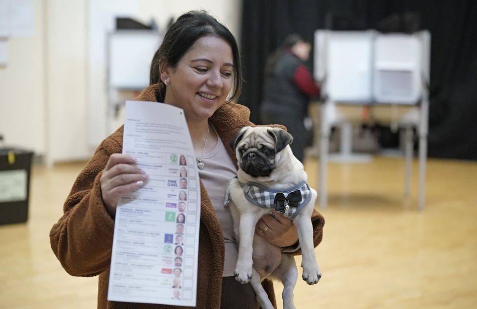 Ms Higgins holds up a ballot paper with Chico still under her other arm (Niall Carson/PA)