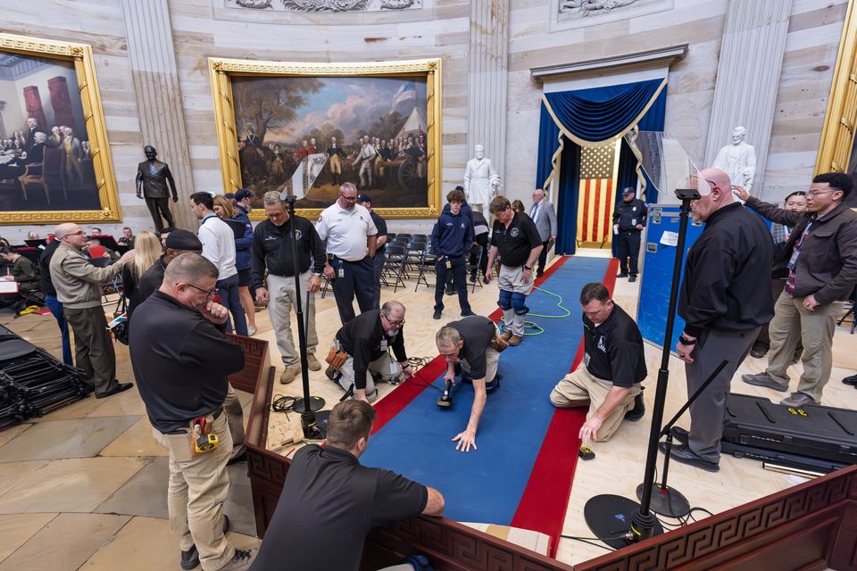 Organisers work to move the Inauguration Day swearing-in ceremony into the Capitol Rotunda (J Scott Applewhite/AP)