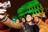 thumbnail: People in Rome taking selfies in front of the ‘greened’ Colosseum.