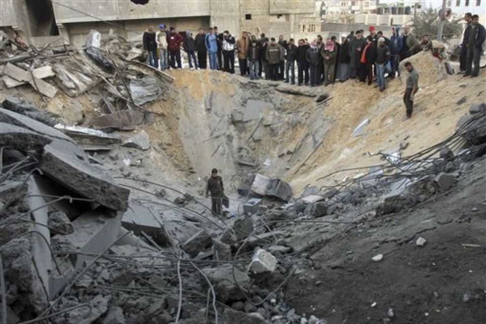 Palestinians gather in the crater of an Israeli missile strike on a building used by the Islamic group Hamas in Gaza City, Sunday, Dec. 28, 2008.  More than 270 Palestinians, have been killed and more than 600 people wounded since Israel's campaign to quash rocket barrages from Gaza began midday Saturday. (AP Photo/Khalil Hamra)