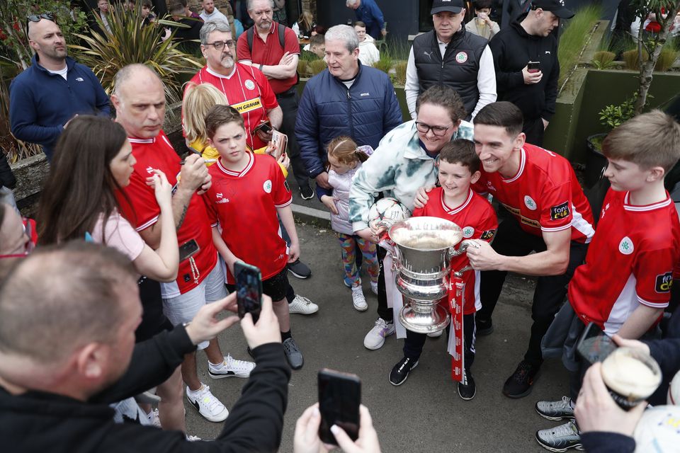 Cliftonville fans get a chance to have their picture taken with the Irish Cup after Cliftonville players arriveed at the Devinish bar on an open top bus to meets supporters, Monday, May 6, 2024.  Picture by Peter Morrison