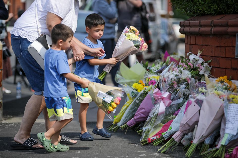 People lay flowers near the scene of the stabbings in Hart Street, Southport (James Speakman/PA)