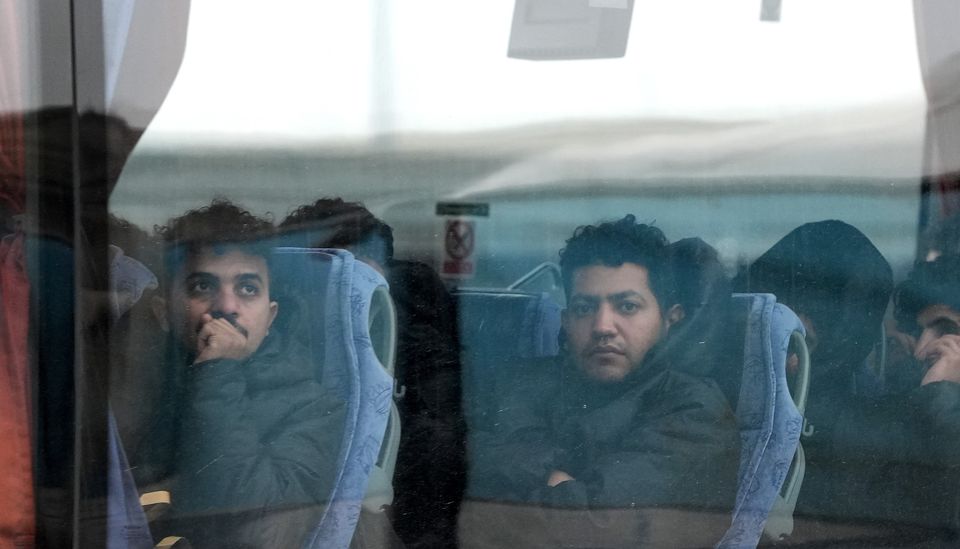 A group of people thought to be migrants are driven away from the Border Force compound in Dover (Gareth Fuller/PA)