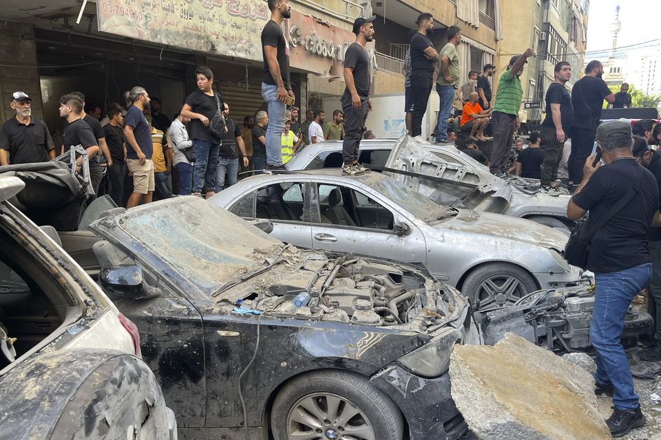 People gather at the scene of an Israeli missile strike in the southern suburbs of Beirut (Bilal Hussein/AP)