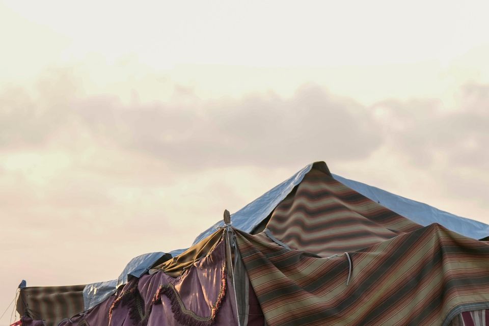 A displaced family fleeing the Israeli air strikes in southern Lebanon sit next to their tent on Beirut’s corniche (Bilal Hussein/AP)