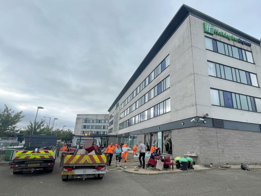 People helped to clear debris at the Holiday Inn Express on Monday (Dave Higgens/PA)