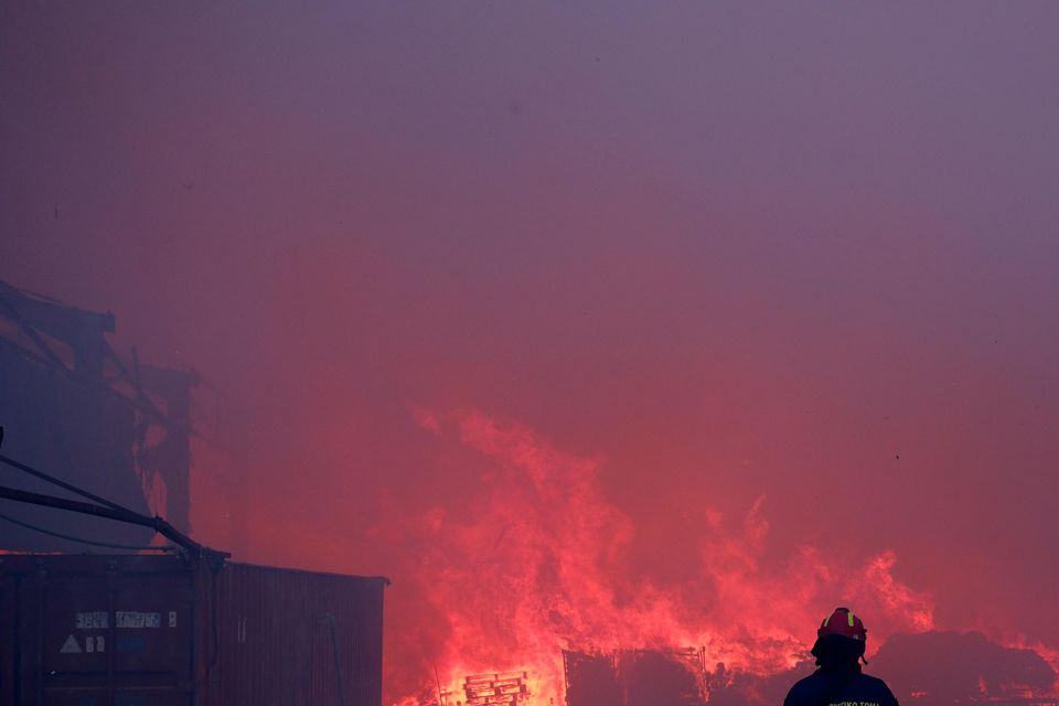 Dozens of homes and businesses were reported to have burned (Aggelos Barai/AP)