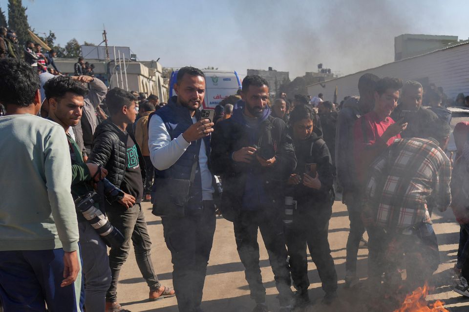 A crowd burns the shirts worn by freed Palestinian prisoners in Khan Younis (Abdel Kareem Hana/AP)