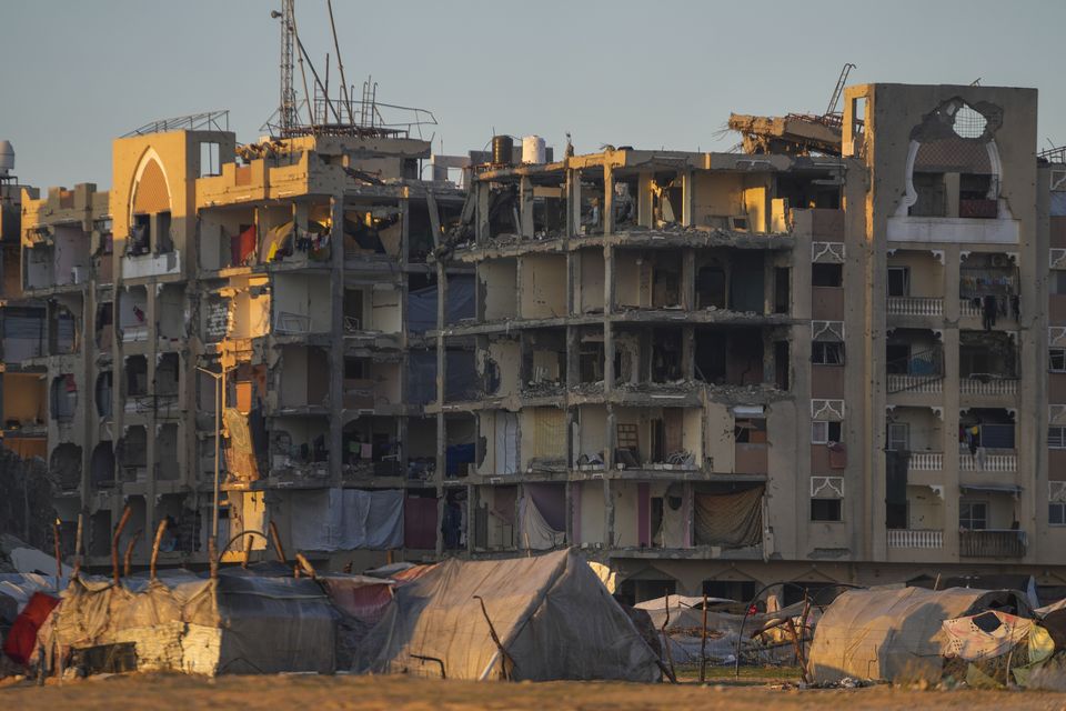 Tents for displaced Palestinians are set up next to buildings damaged by Israeli army strikes in Khan Younis (Abdel Kareem Hana/AP)