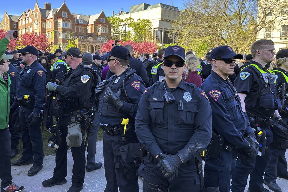 Police in the US gather as they start removing tents erected by protesters from the campus of University of Wisconsin (Todd Richmond/AP)