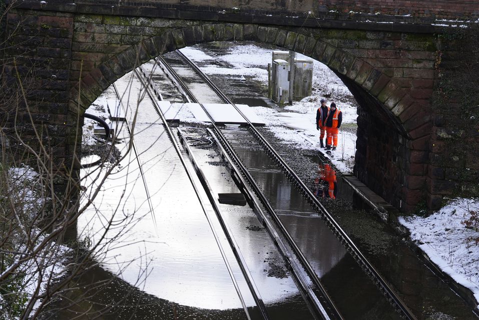 Rail workers inspect flooding on the line between Capenhurst railway station and Hooton in Cheshire (Peter Byrne/PA)