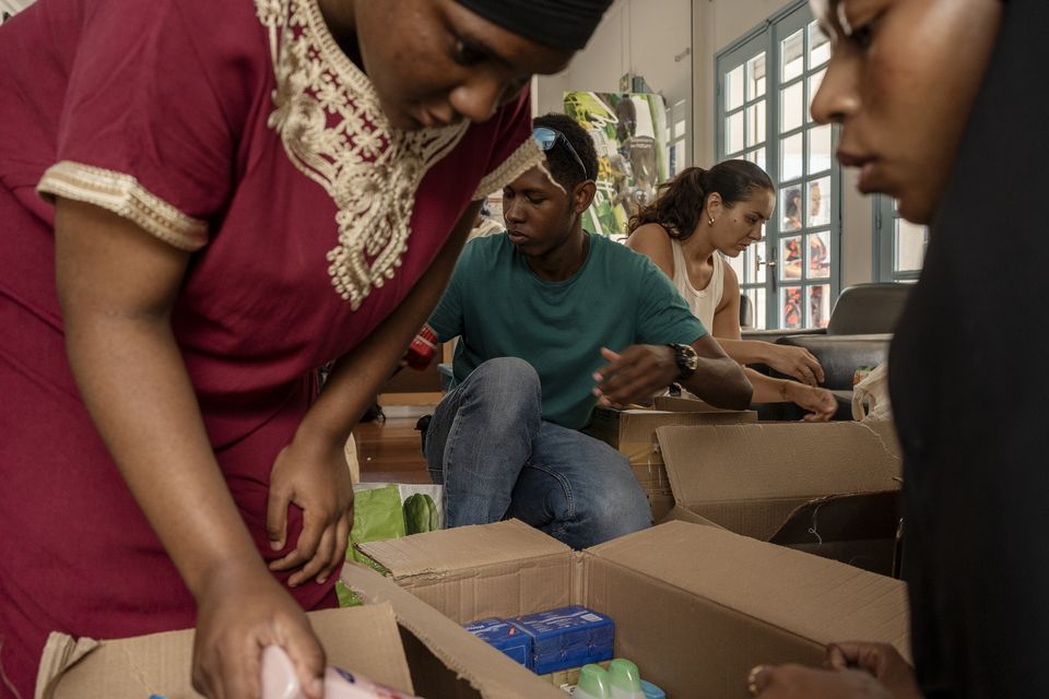 Volunteers sort through donations for victims of Cyclone Chido in Mayotte (Adrienne Surprenant/AP)