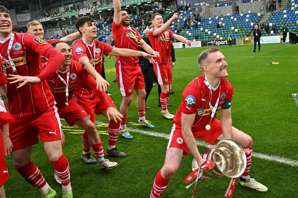 Chris Curran prepares to lift the Irish Cup in front of his Cliftonville team-mates