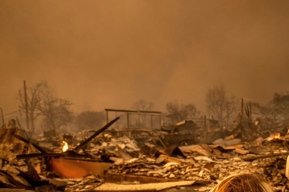 A couple returned to their fire-damaged home after the Eaton blaze swept through the area in Altadena (Ethan Swope/AP)