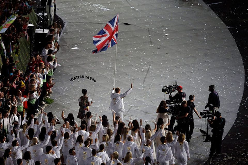 Britain's Chris Hoy carries the flag during the Opening Ceremony at the 2012 Summer Olympics, Friday, July 27, 2012, in London. (AP Photo/Charlie Riedel)