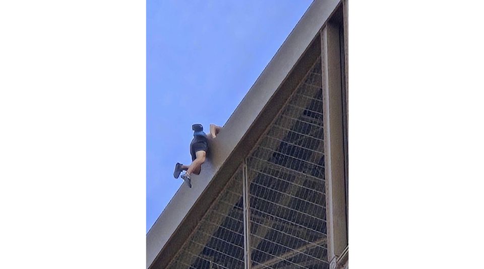 A man climbs the Eiffel Tower (Nickey Worlock via AP)