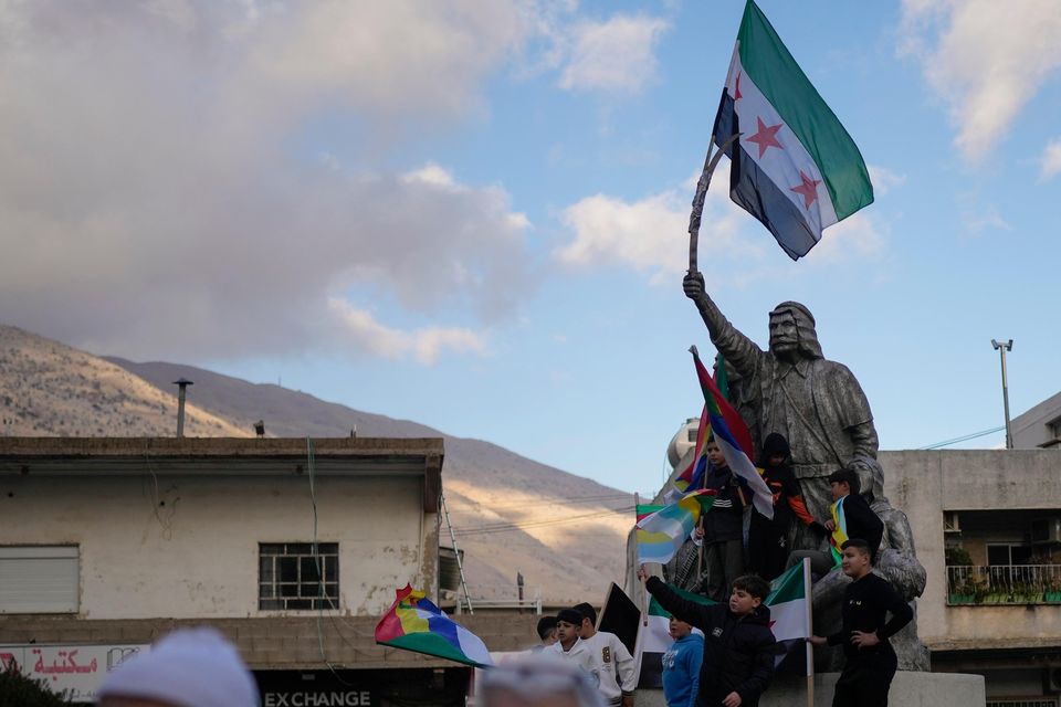 People attend a rally celebrating the fall of Syrian President Bashar Assad’s government. It comes as the prime minister said that Cabinet ministers were back at work (AP Photo/Matias Delacroix)