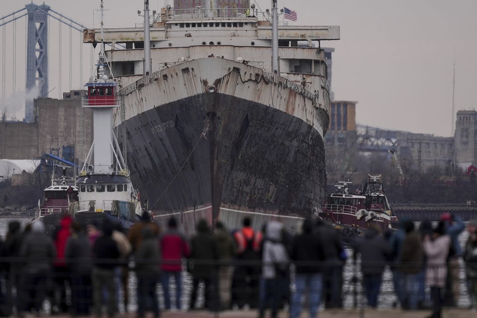 People line the waterfront to see the SS United States as she is towed down the Delaware River between Pennsylvania and New Jersey, from Philadelphia (Matt Rourke/AP)