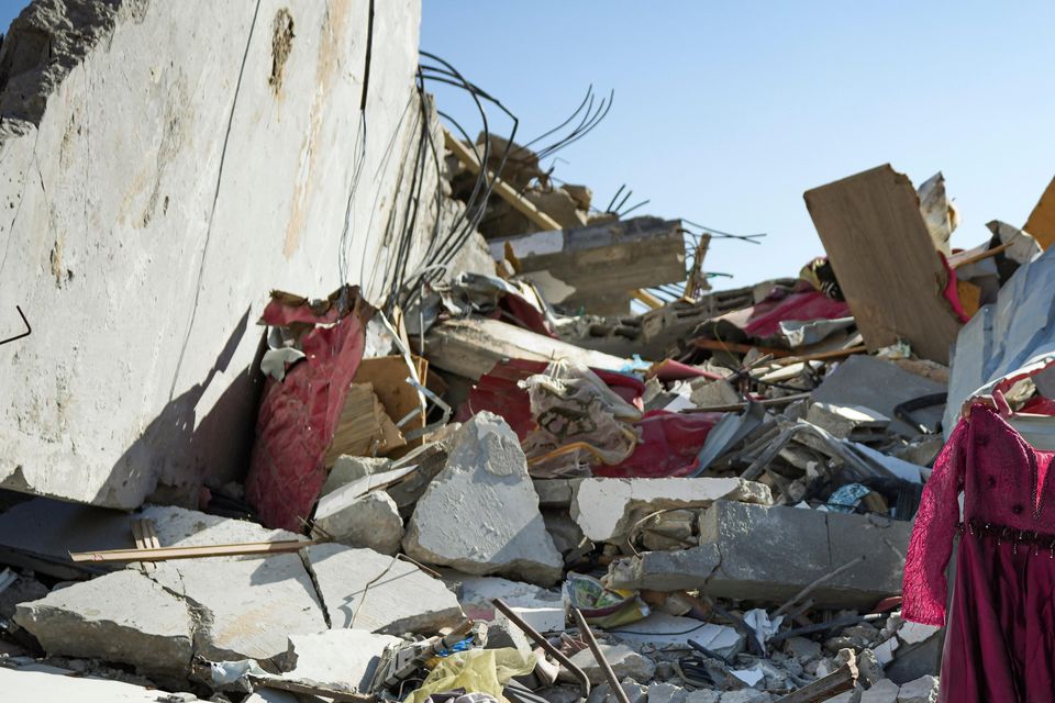 Nour Abu Al Zamar was among thousands of people trying to salvage items from under the rubble of her destroyed family home in Rafah (AP)