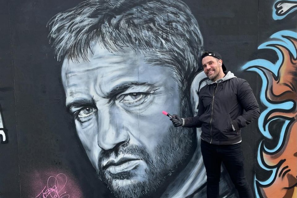 Johnny Hamilton pictured with the mural in Bangor